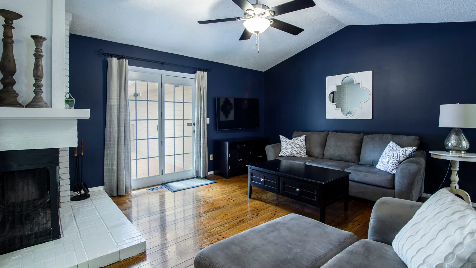 Living room with navy walls, a fireplace, and sliding patio doors