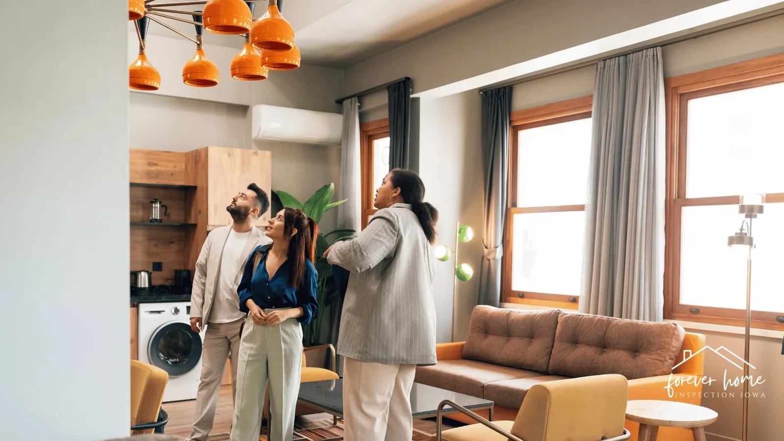 Agent showing a couple around a bright, open living area