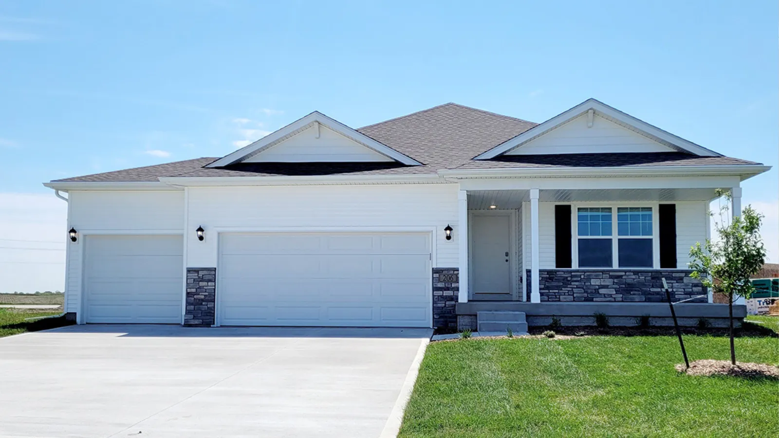 White ranch-style home with a three-car garage and stone accents