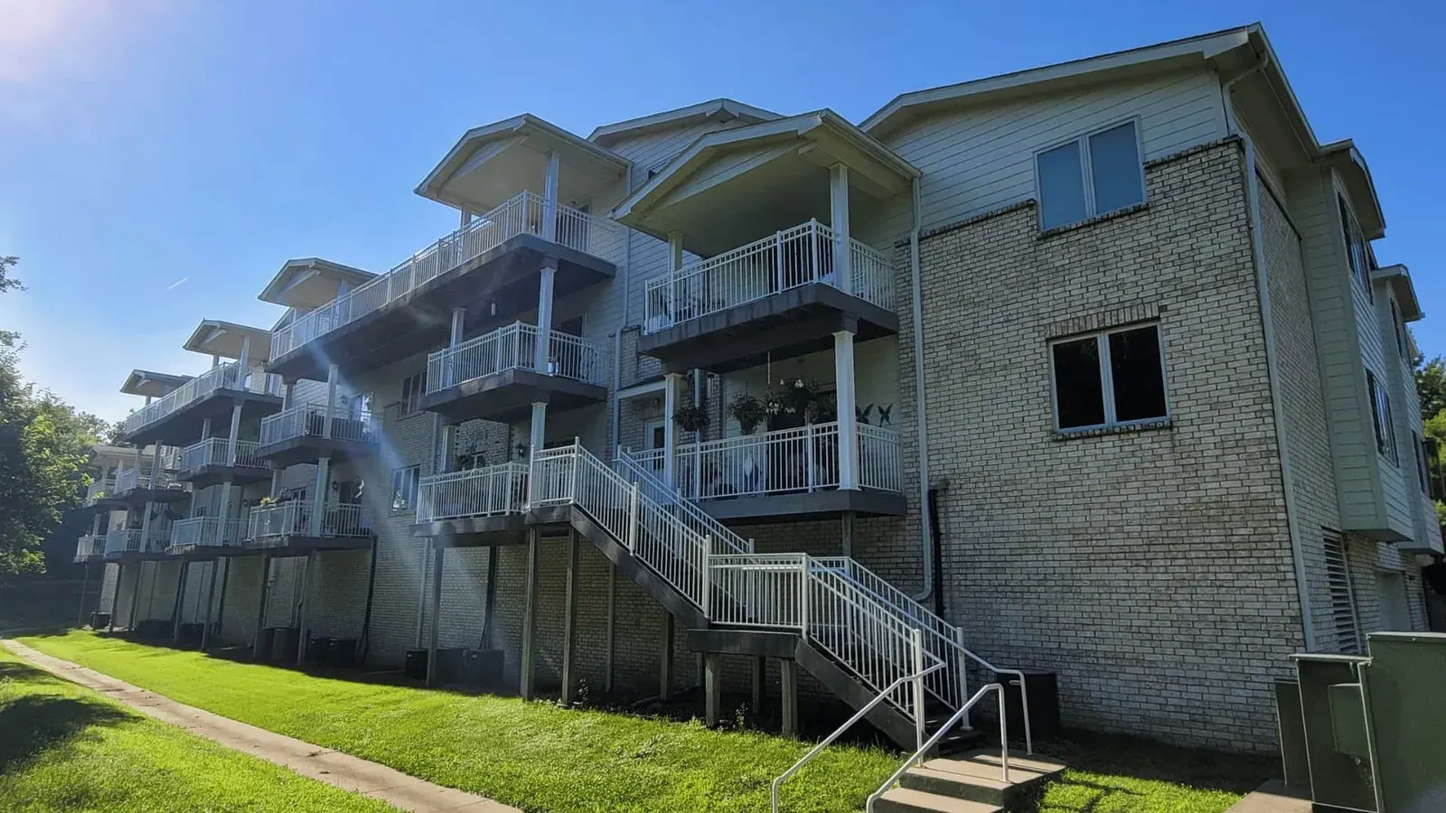 Multi-story apartment building with stacked balconies and exterior stairs