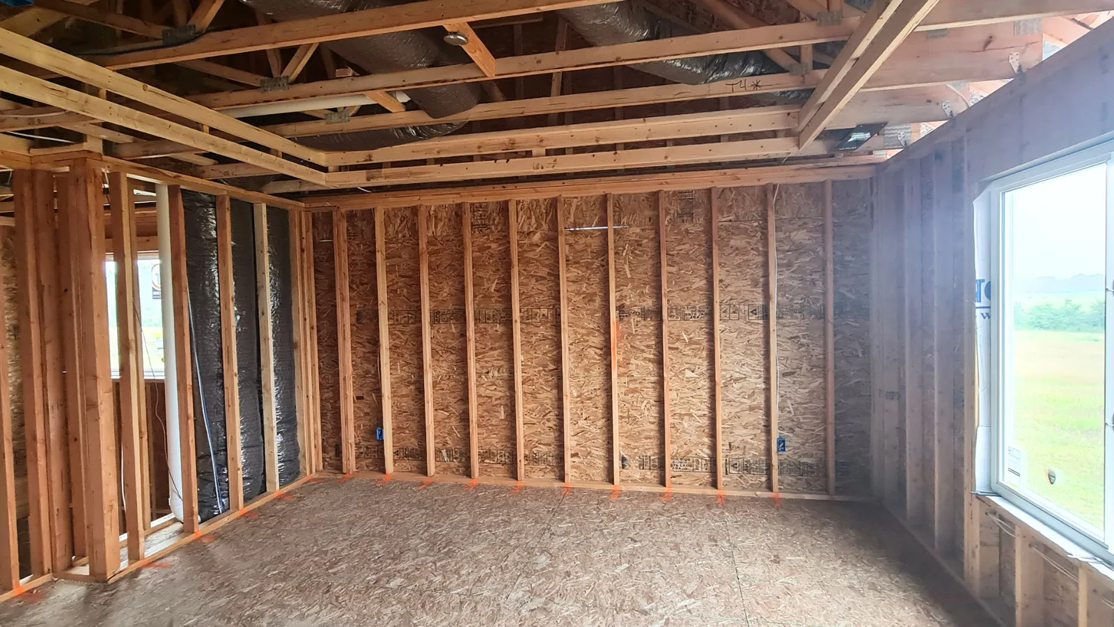 Wood-framed interior of a home under construction before drywall