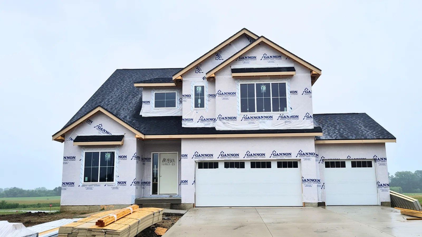 Two-story home under construction wrapped in house wrap