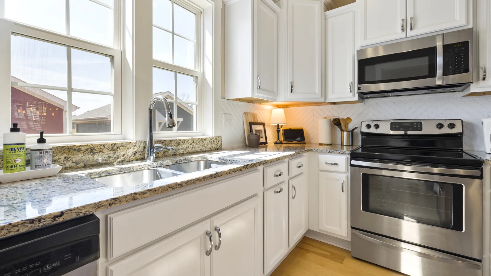 Kitchen with white cabinets, granite counters, and stainless appliances