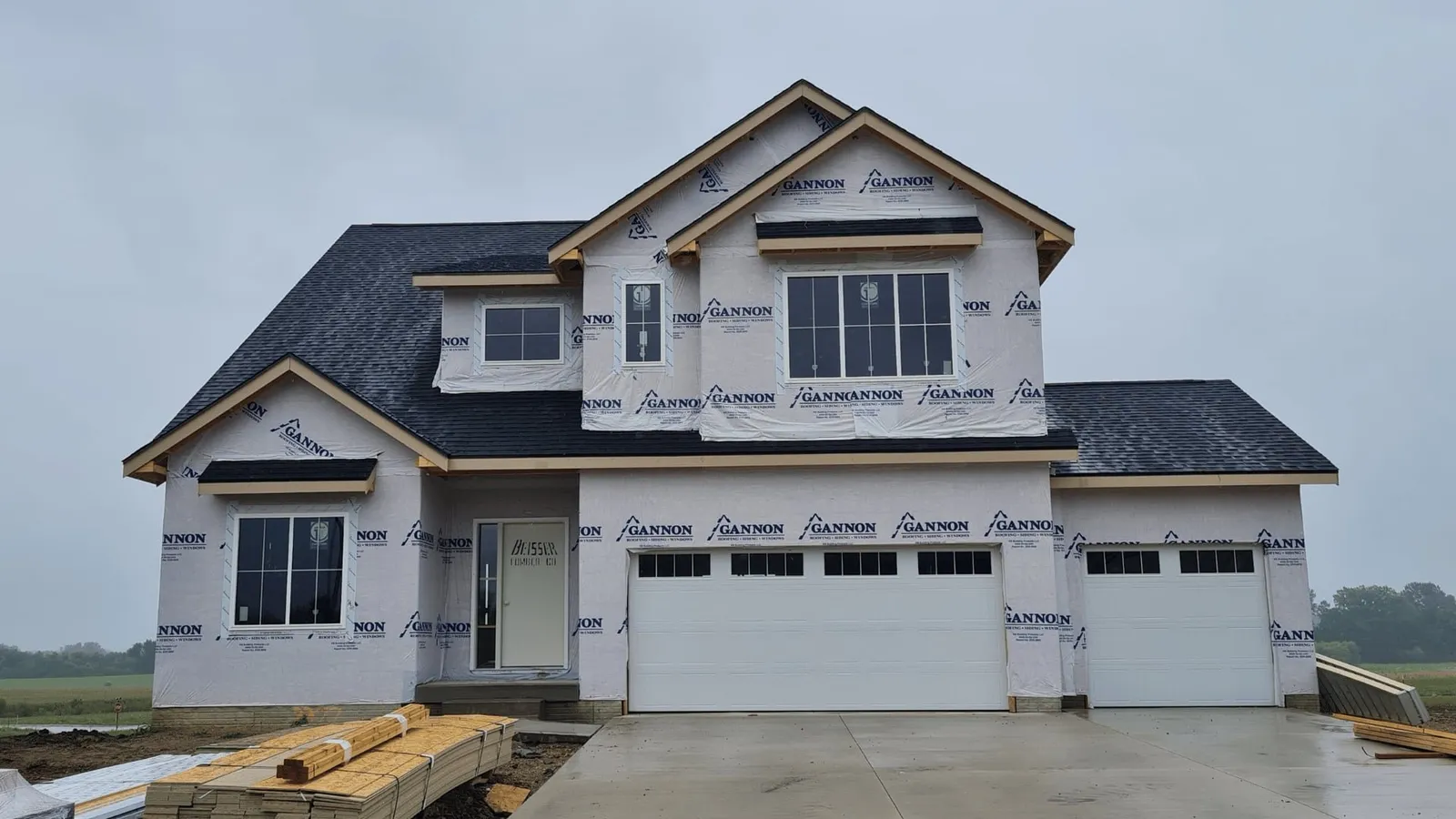 Two-story home under construction wrapped in house wrap