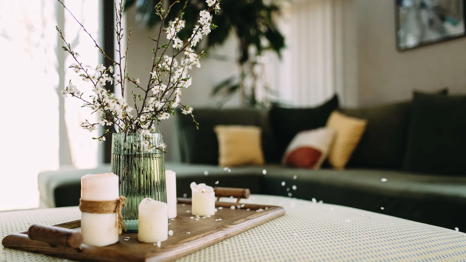 Living room coffee table with candles and a vase of flowers