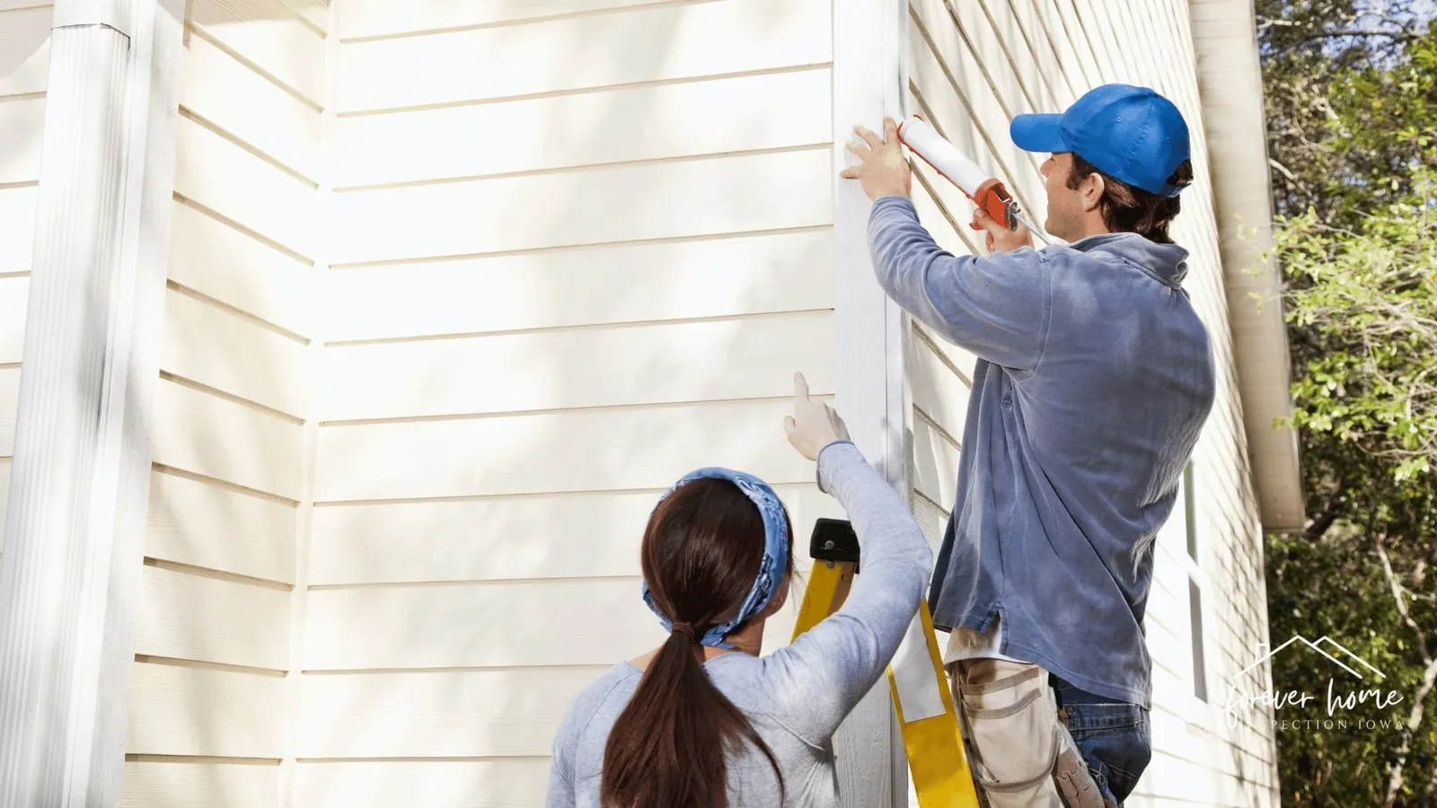 Inspector pointing out something on exterior siding to a homeowner