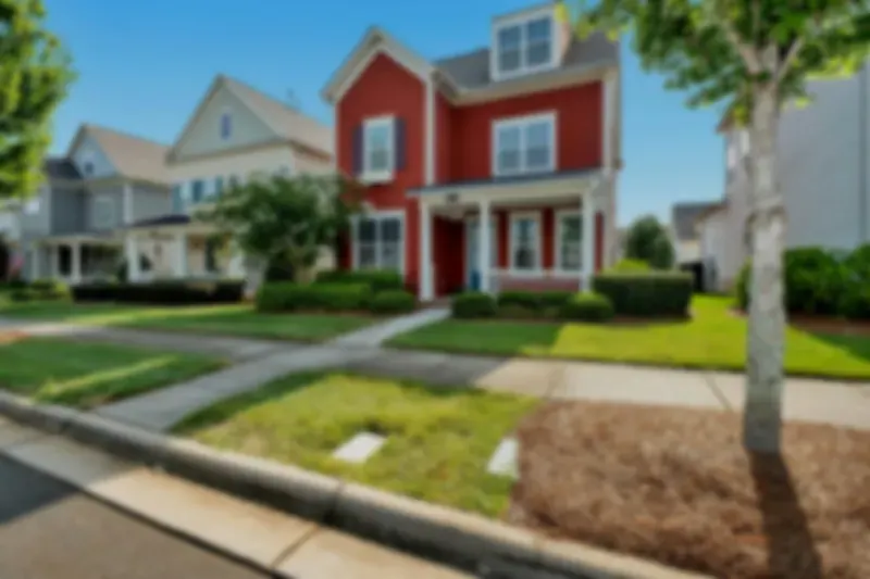 Colorful homes lined up along a residential street with a sidewalk