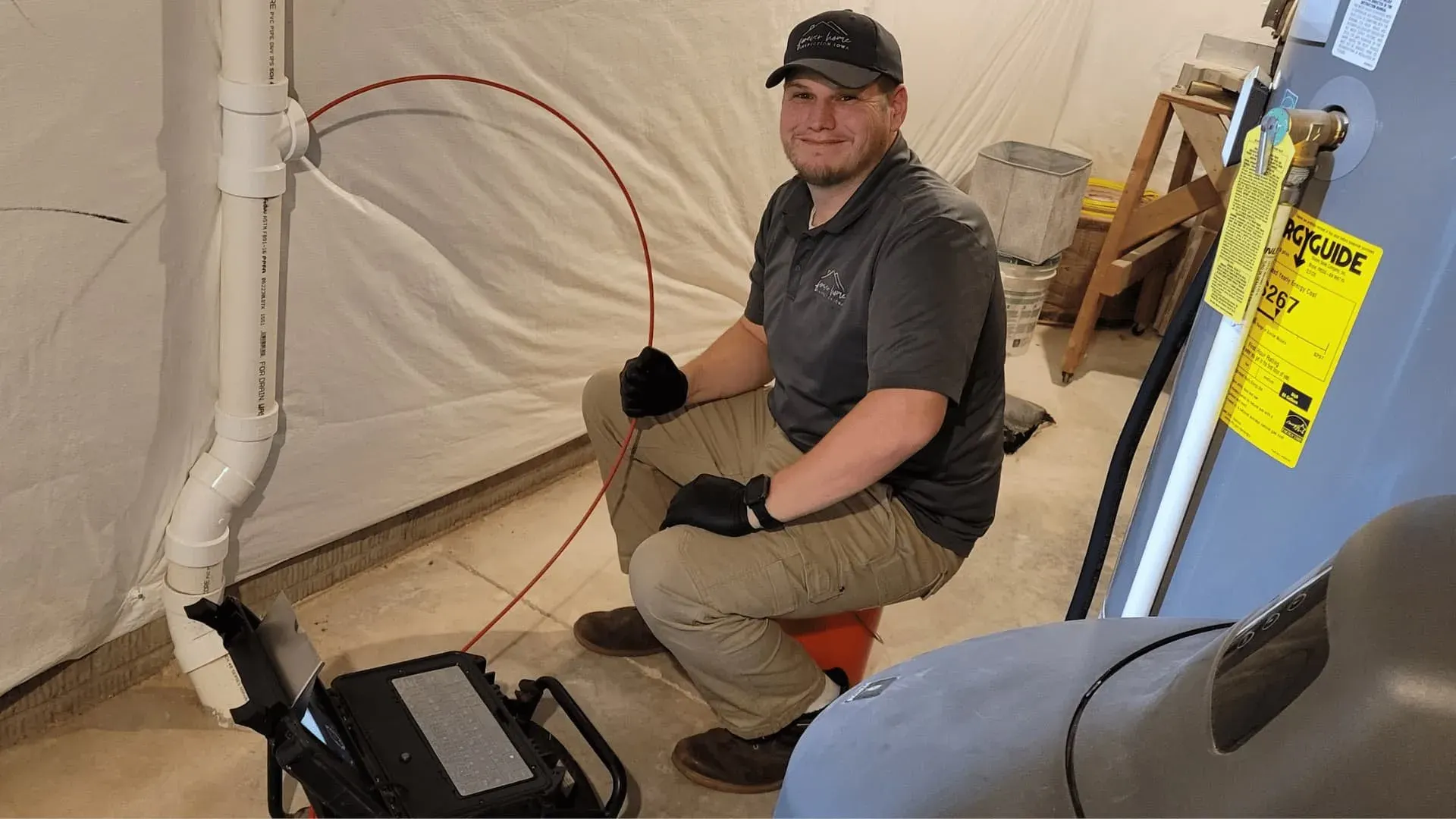 Matt smiling beside the sewer scope camera