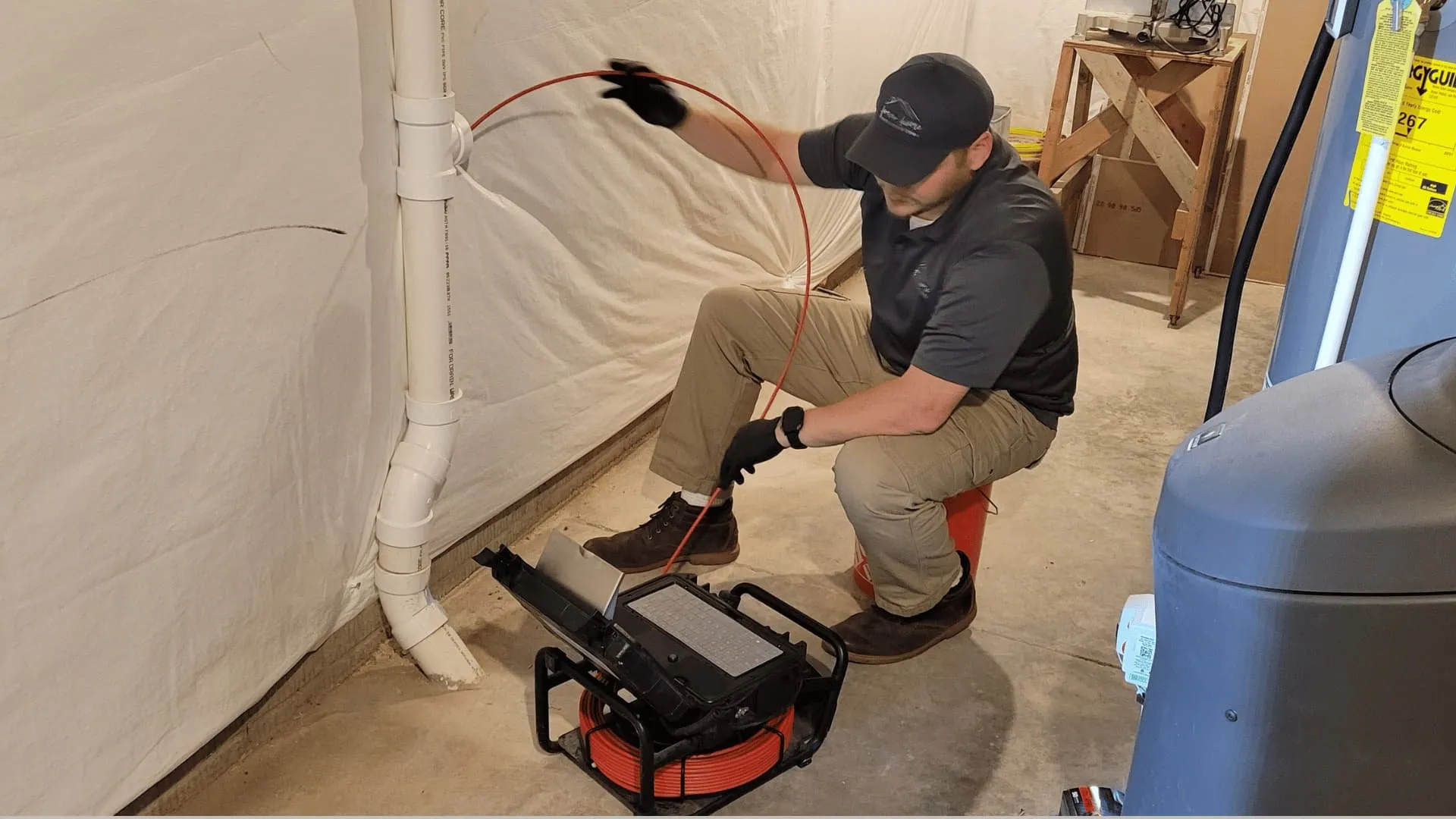 Inspector running a sewer camera from a basement cleanout