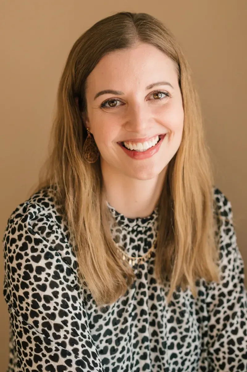 Kalyn Gibson in a leopard-print blouse against a warm tan background